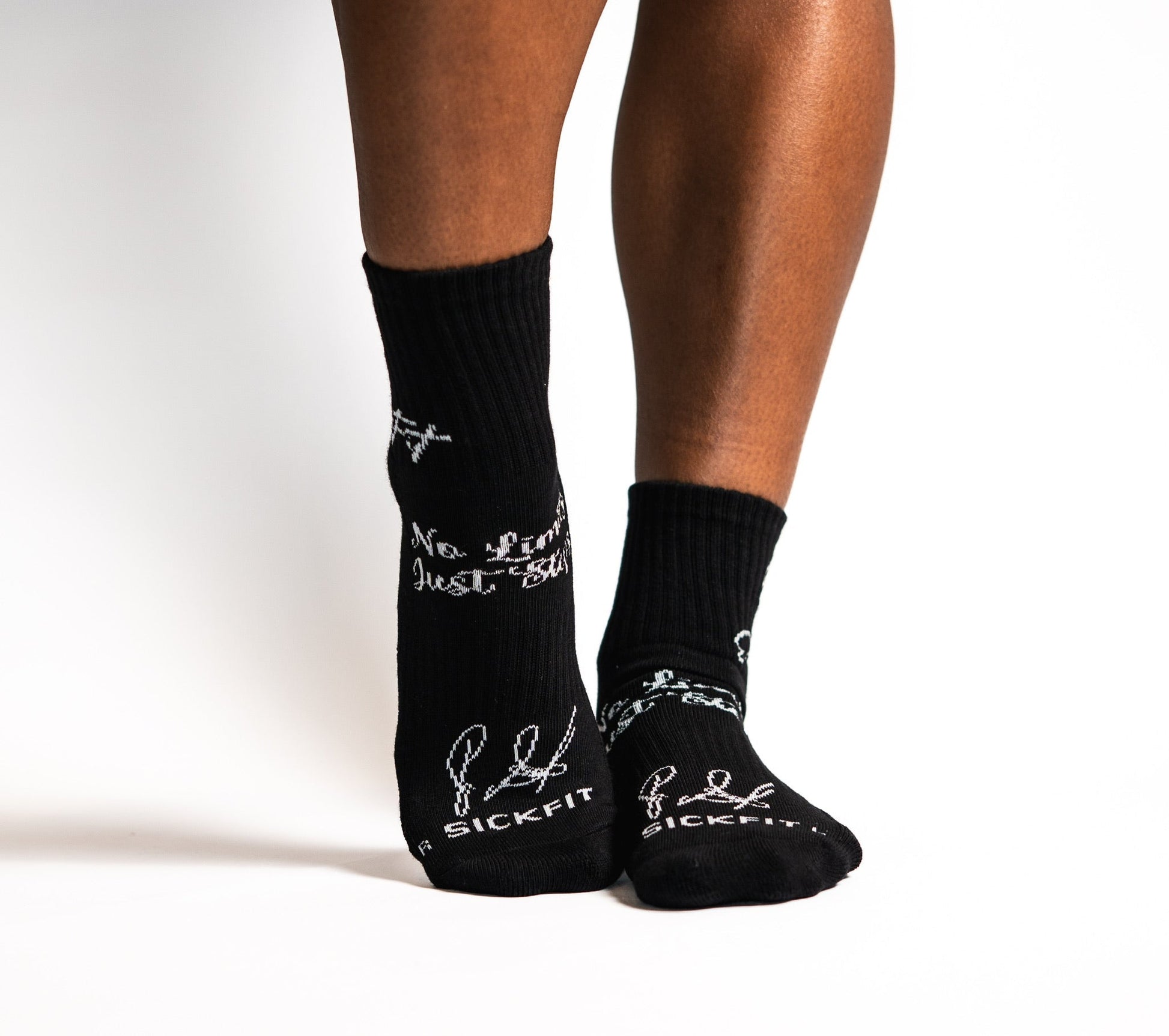 Black crew ocks with white text and graphics worn by a person on a light background